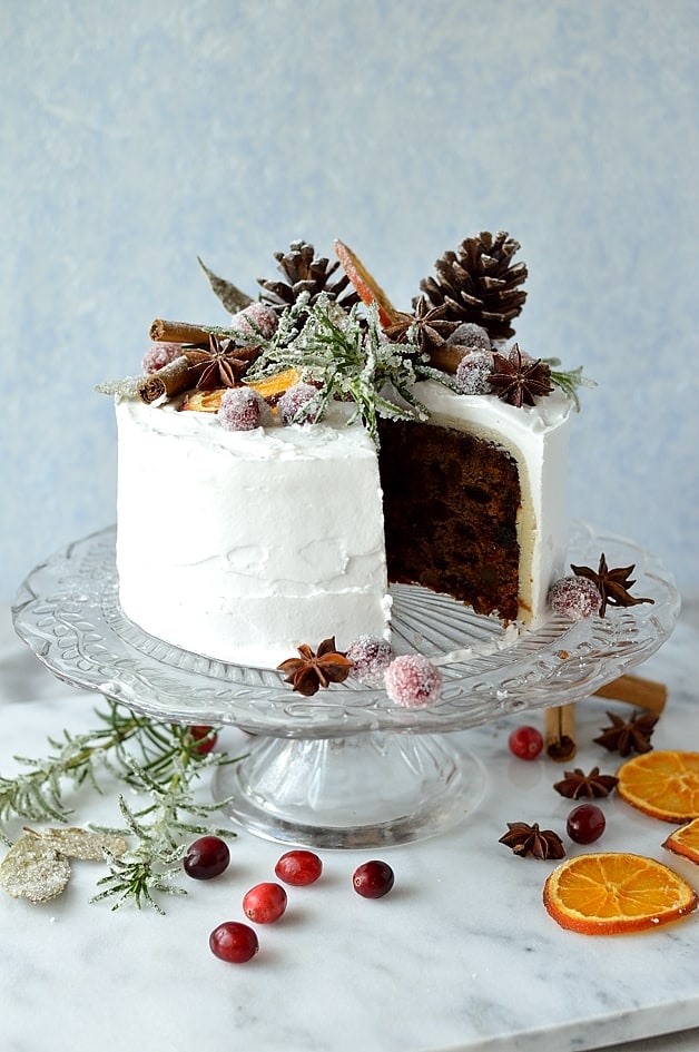 Moist, gingery fruitcake topped with marzipan, royal icing, sugared cranberries, rosemary and bay leaves, dried orange slices, pine cones and whole spices - Domestic Gothess