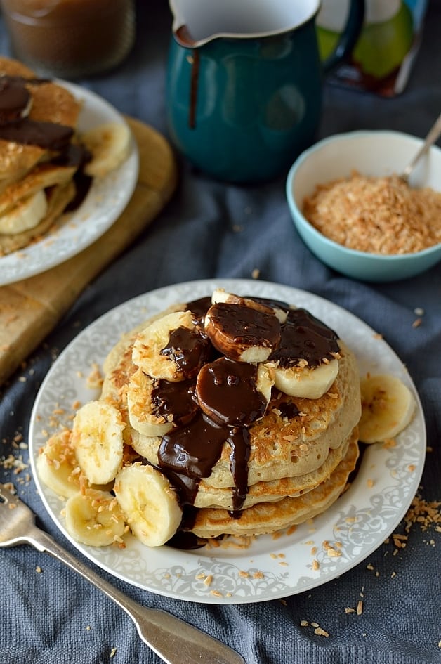 Delicious toasted coconut pancakes with chocolate fudge sauce and banana (dairy-free)