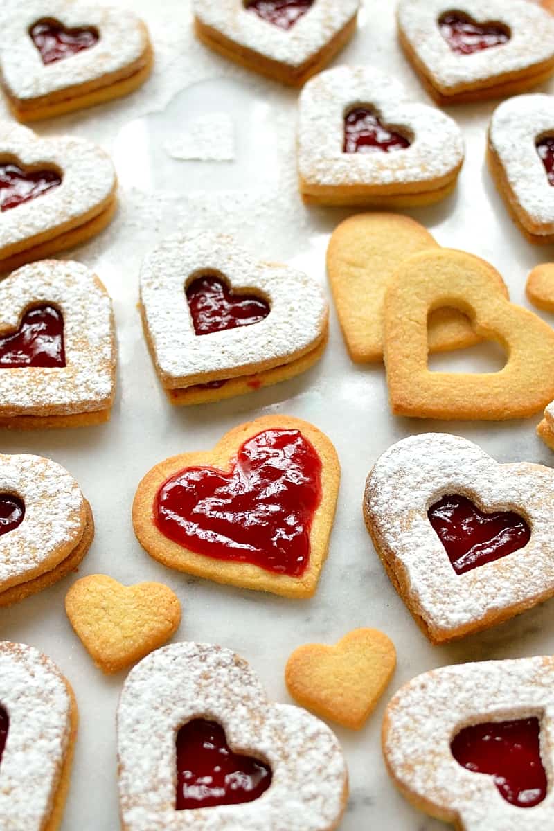 Valentine's Day Linzer biscuits (cookies) - delicious heart shaped almond biscuits filled with raspberry jam.