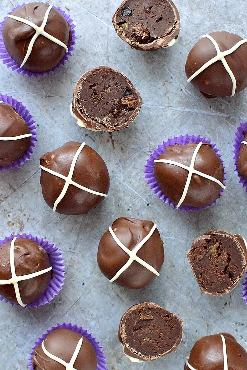 Hot cross bun chocolate truffles - rich, decadent chocolate ganache truffles flavoured with spices and mixed dried fruit, topped with a white chocolate cross.