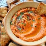 Roasted red pepper and chili hummus with home-made seasoned pitta chips. Easy to make and the perfect snack!