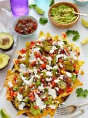 Loaded veggie nachos - topped with two kinds of beans, corn, salsa, guacamole, cheese and sour cream, this is the best way to eat a bag of chips for dinner!