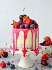 Mini white chocolate berry drip cake - delicious, moist vanilla cake with whipped white chocolate gananche, pink white chocolate drip and fresh berries; serves just 2-4 people!