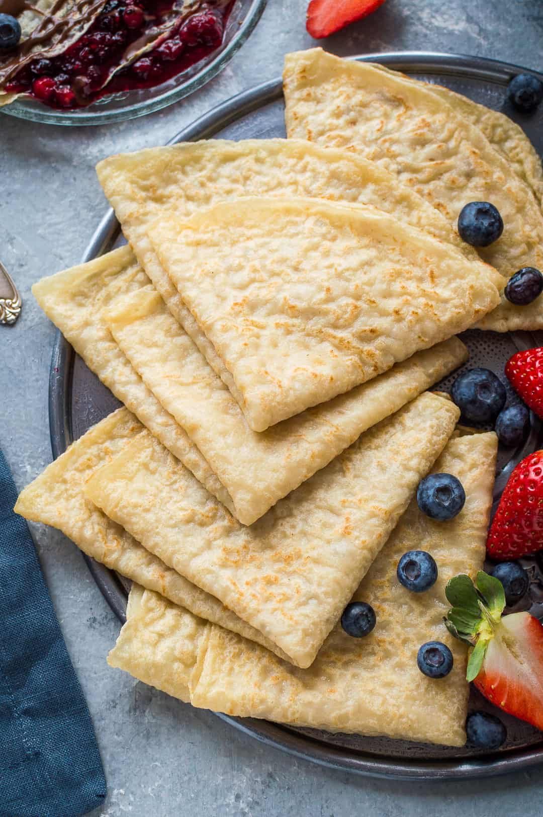 A plateful of egg and dairy free vegan crepes (pancakes) with fresh berries.