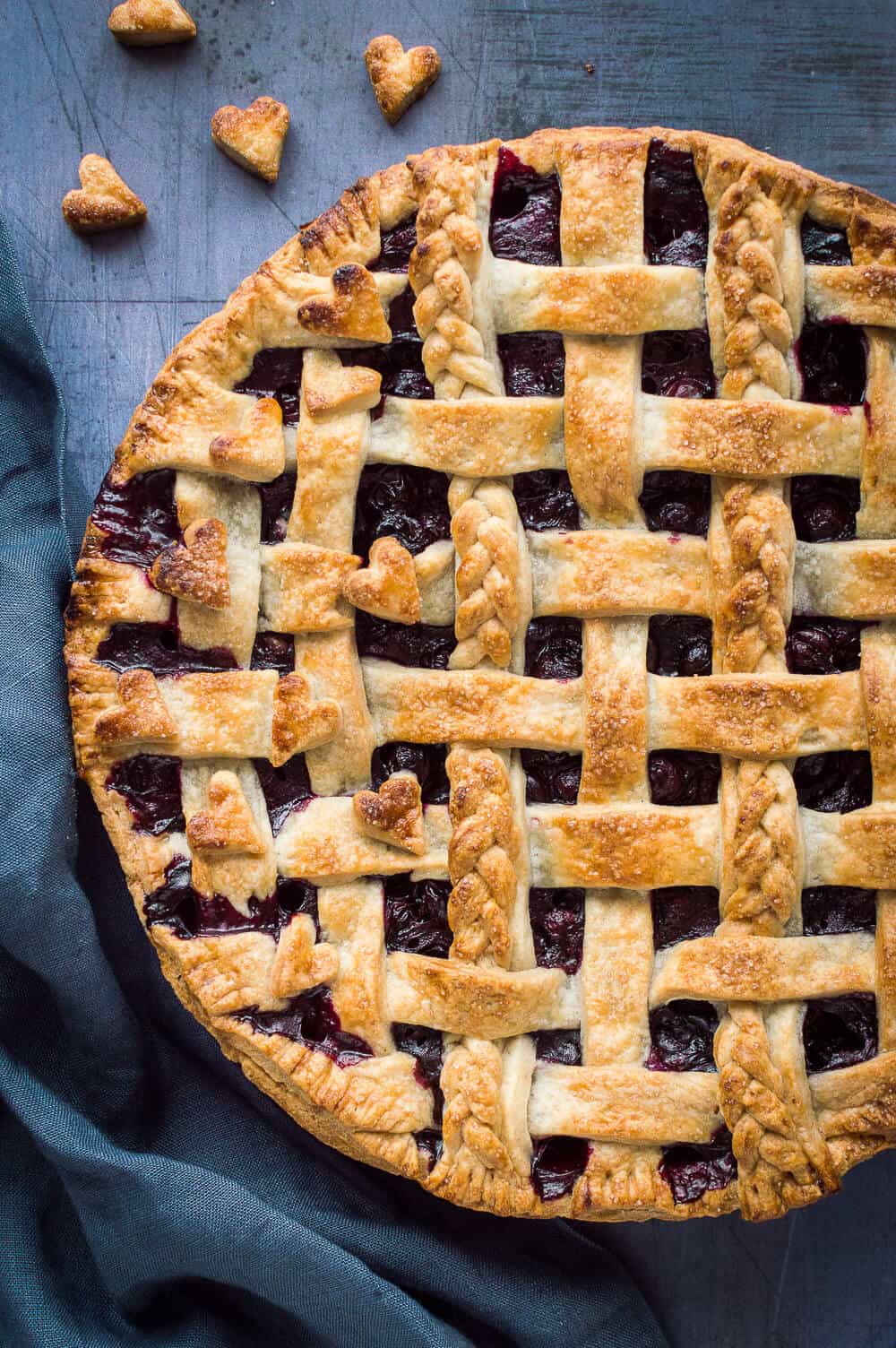 A close up of lattice topped vegan blueberry pie