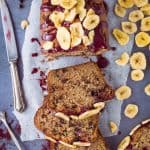 Vegan chocolate chip banana bread - a vegan version of everyone's favourite bake. Easy to make using storecupboard ingredients, packed with chocolate chips and topped with a blueberry glaze; this banana bread is seriously good!
