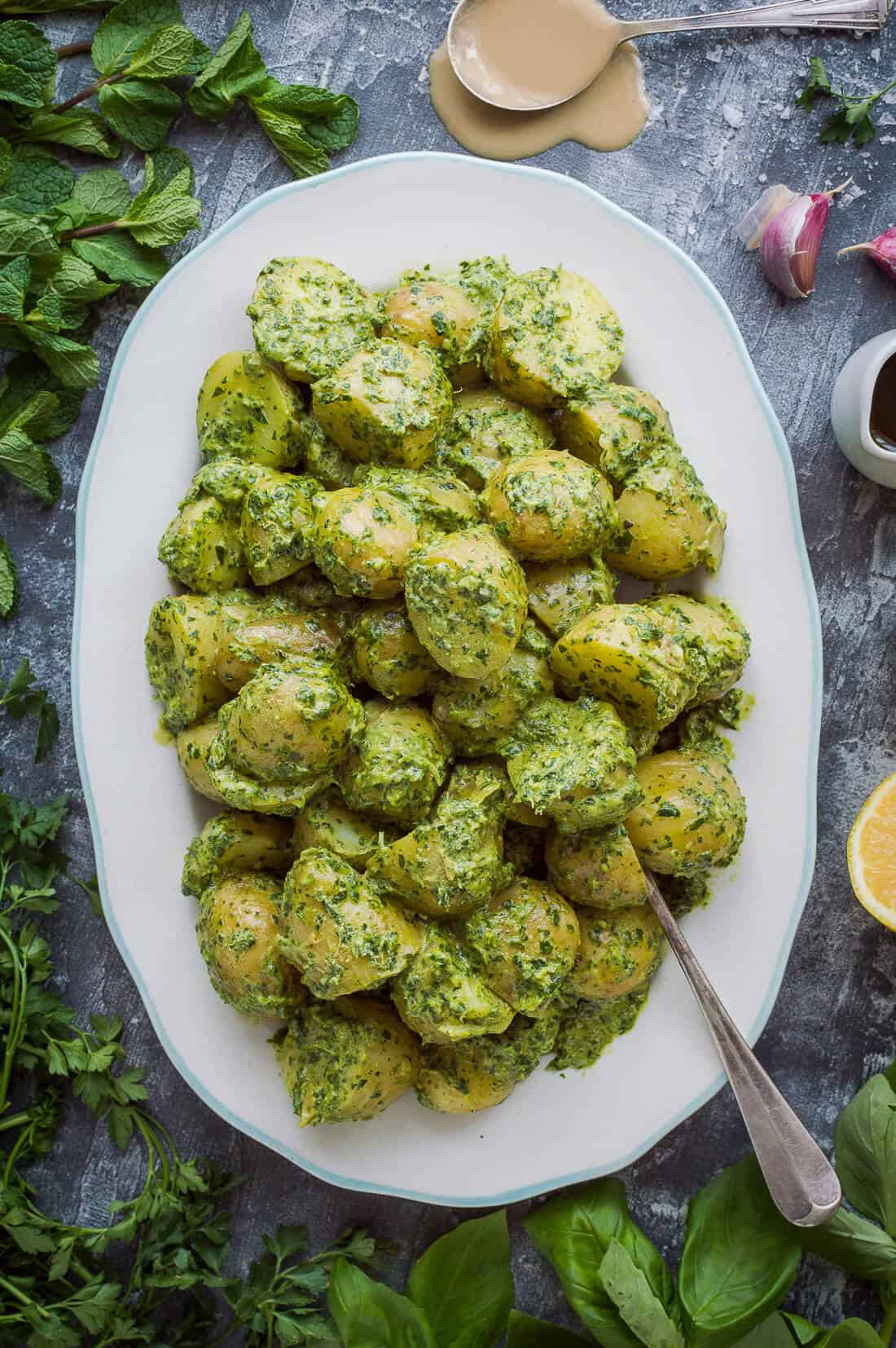 Potato salad with tahini herb dressing - warm Jersey Royal new potatoes tossed with a delicious tahini, herb and lemon dressing. The perfect side dish for Spring! (Vegan). #vegan #potatosalad