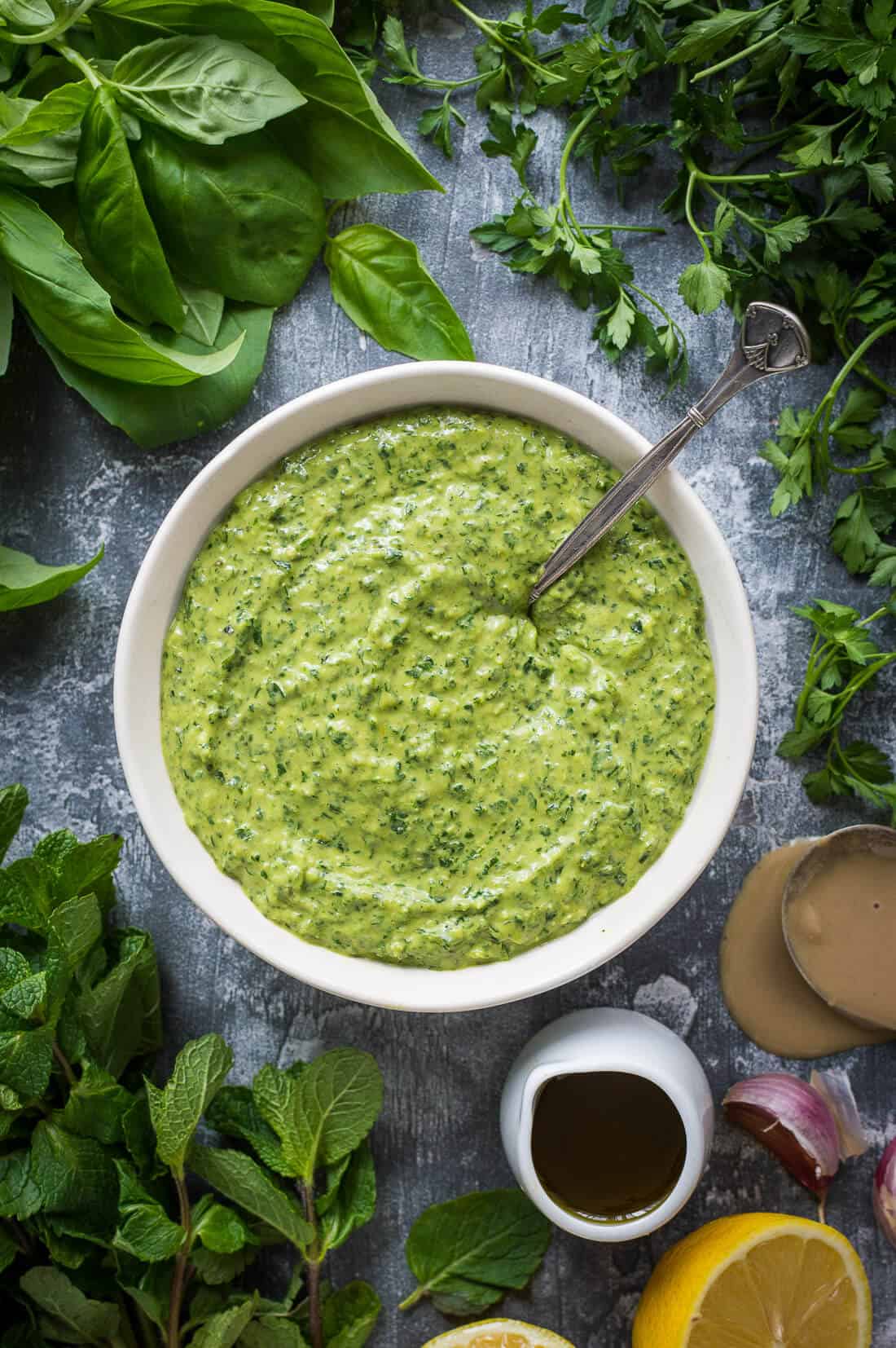 Tahini herb dressing - a gloriously green tahini, herb and lemon dressing that is perfect on potatoes, salad, pasta, tacos, in wraps or as a dip. Vegan/dairy free. #vegan #sauce