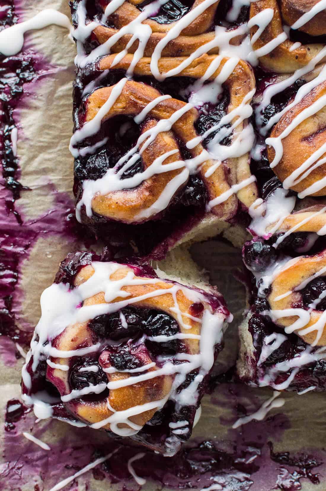 Vegan lemon blueberry rolls - soft, sticky vegan sweet rolls filled with juicy blueberries and topped with a tangy lemon glaze. With step by step photos! #vegan #cinnamonrolls #sweetrolls #blueberries #bread #baking #lemon #dairyfree