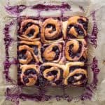 Nine vegan lemon blueberry rolls in a square on a sheet of baking parchment.