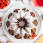 Vegan ginger bundt cake with lime glaze and macerated strawberries – a moist, spicy, easy to make cake served with juicy strawberries; perfect for afternoon tea! #gingerbread #vegan #vegancake #veganbaking #dairyfree #eggfree #bundtcake