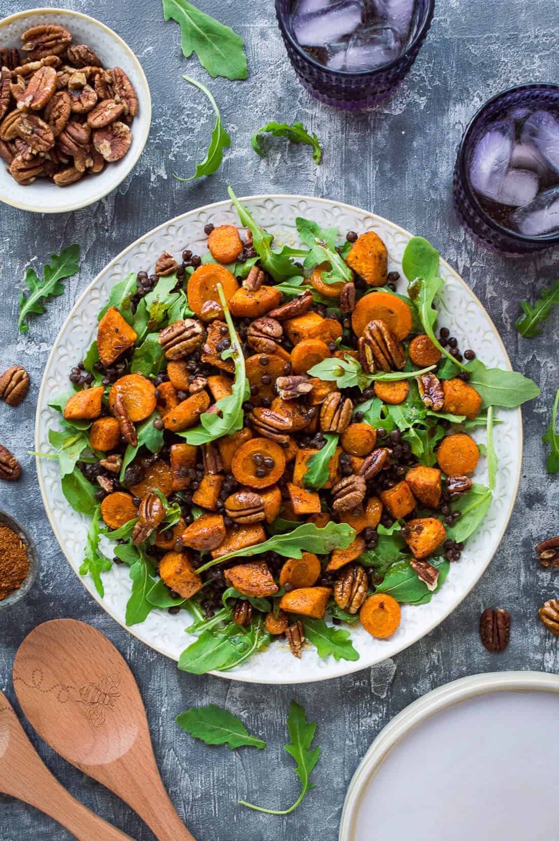 A plate of vegan roasted sweet potato, lentil and rocket salad with toasted pecans and pomegranate molasses dressing