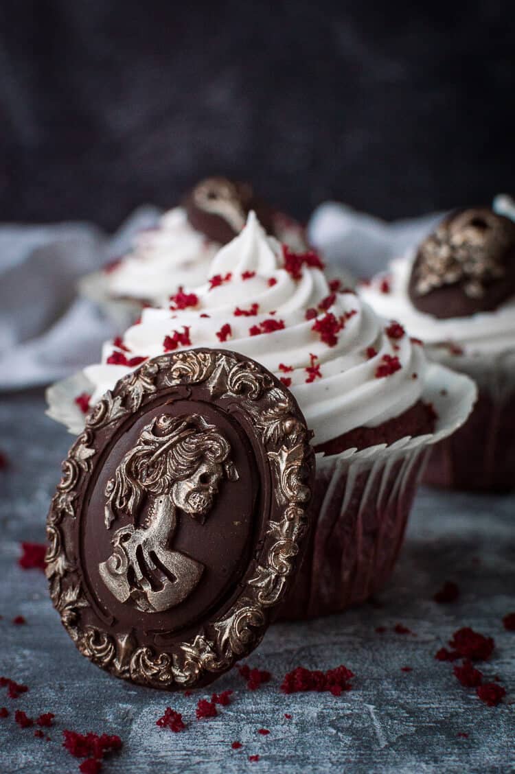 Vegan red velvet cupcake with a chocolate skull cameo with gold detailing for Halloween.