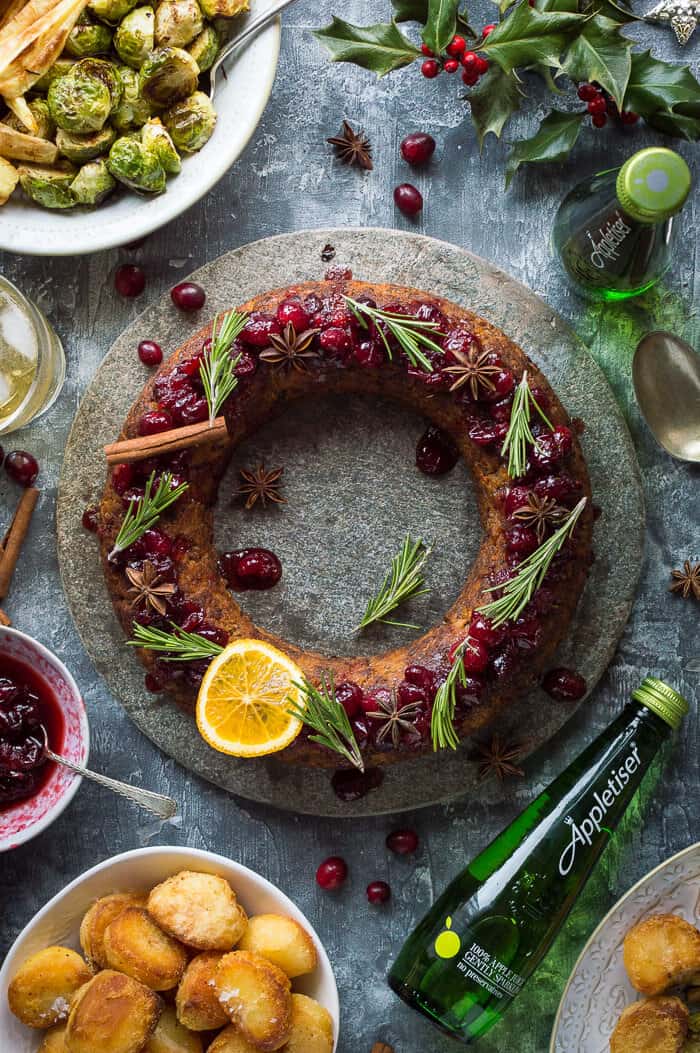 Festive vegan nut roast wreath with roast potatoes, Brussel sprouts and cranberry sauce.