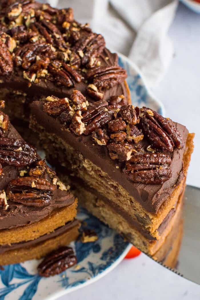 close up of maple pecans on top of vegan maple pecan cake with chocolate cashew cream frosting.