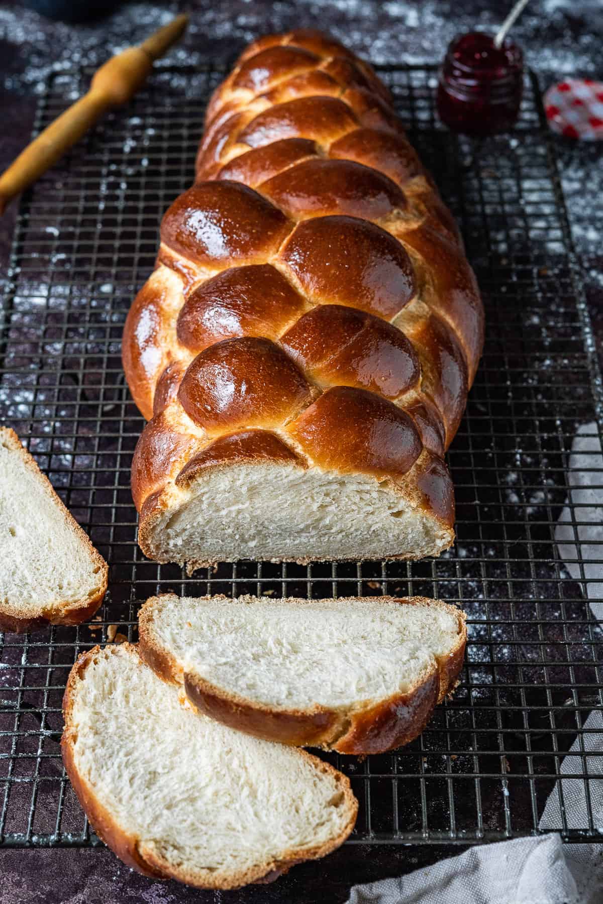a sliced loaf of water challah on a wire rack.