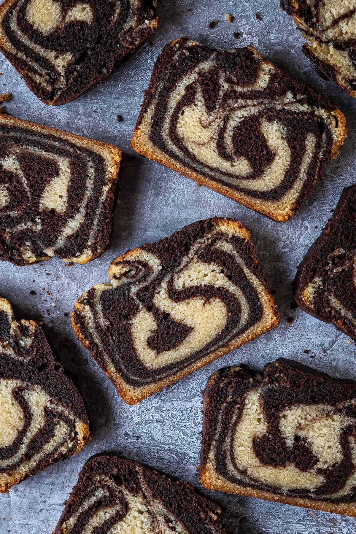 Slices of vegan marble cake on a grey background.