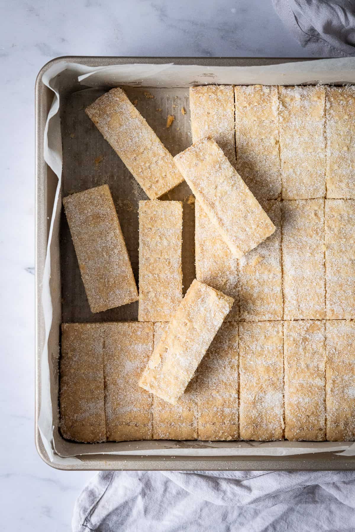 Close up of vegan shortbread fingers in a square metal cake tin.
