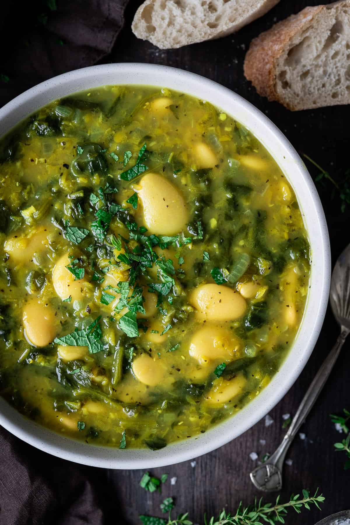 Close up of a bowl of spinach, lentil and butter bean soup.