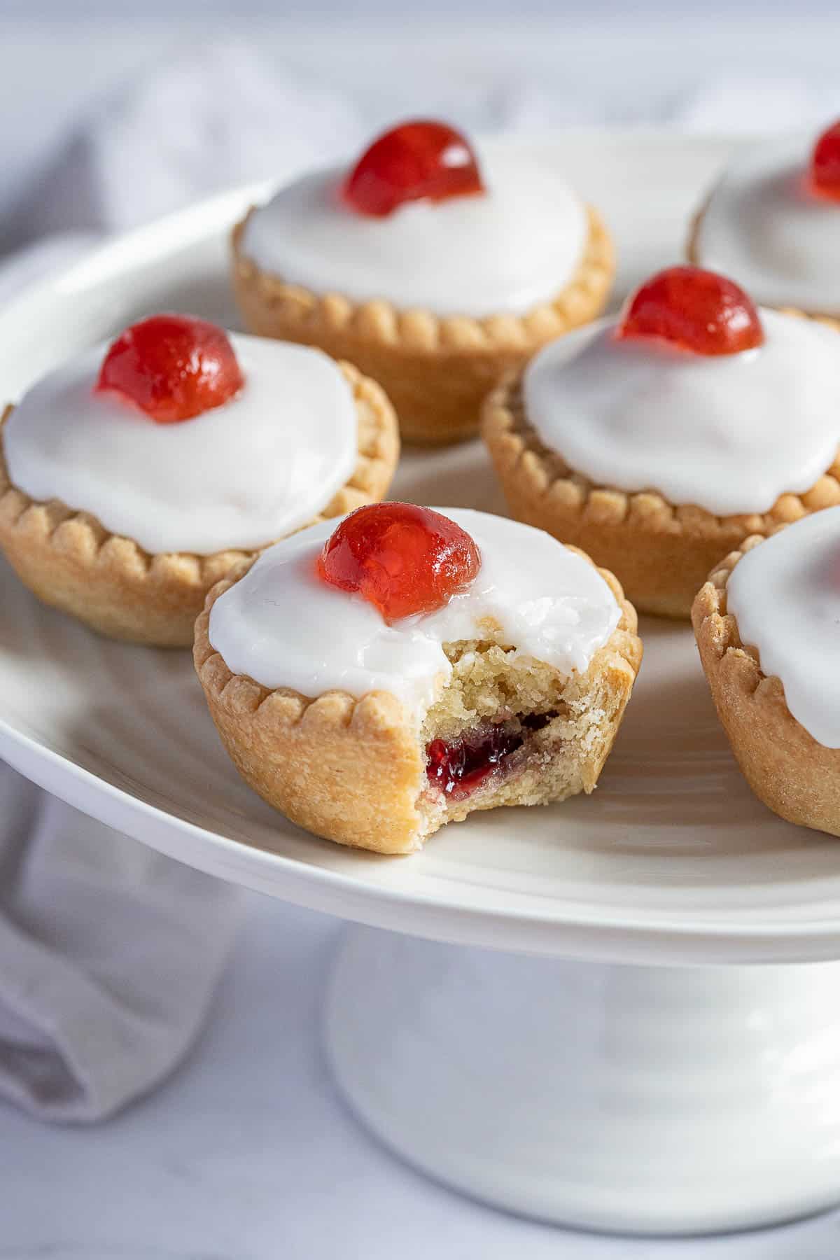 Close up of a vegan cherry Bakewell with a bite taken out of it.