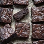 Close up of fudgy vegan brownies, one on it's side.