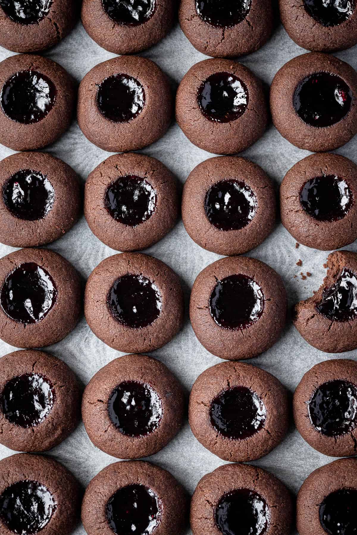 Rows of chocolate cherry thumbprint cookies.