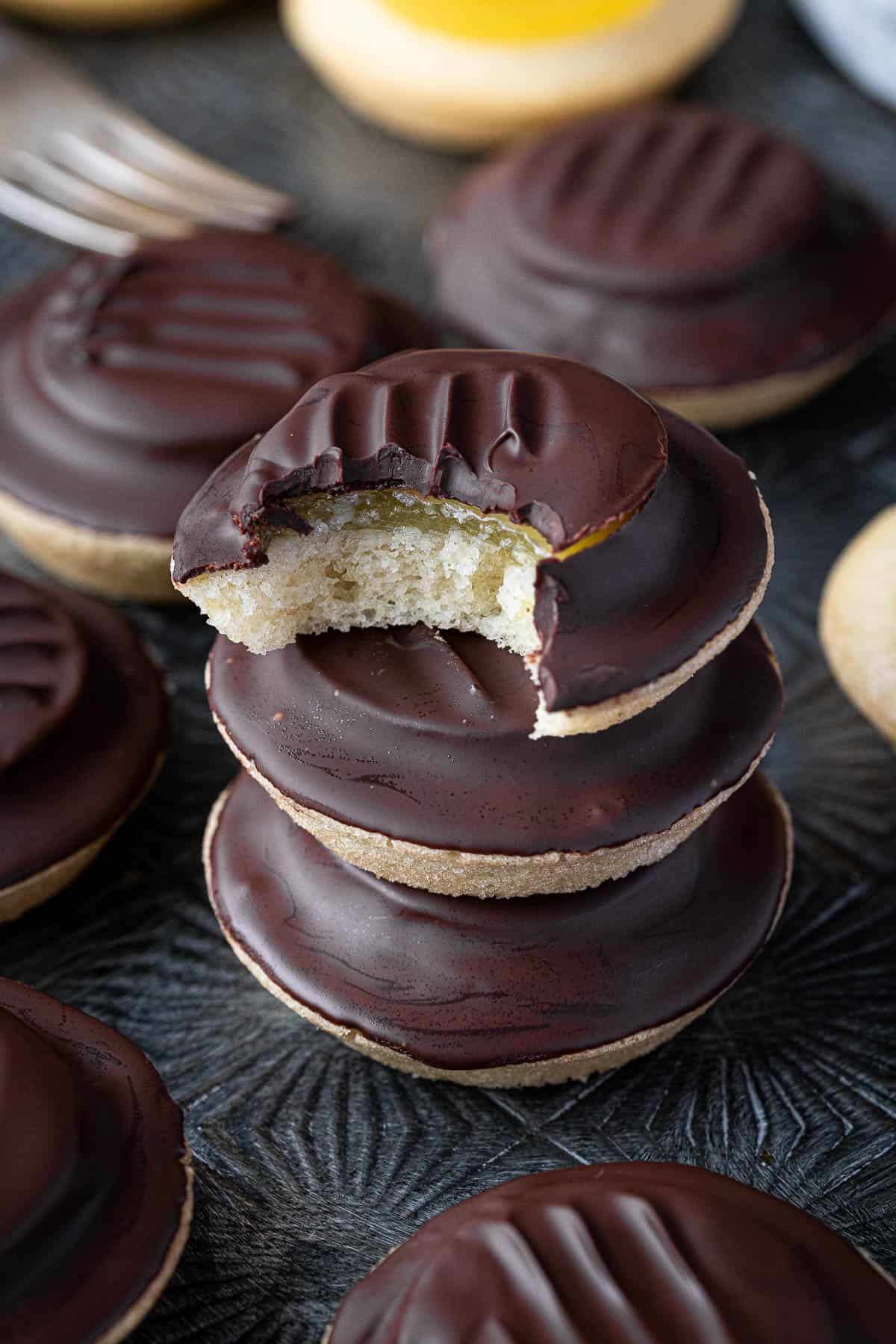 A stack of vegan jaffa cakes, one with a bite taken out of it.