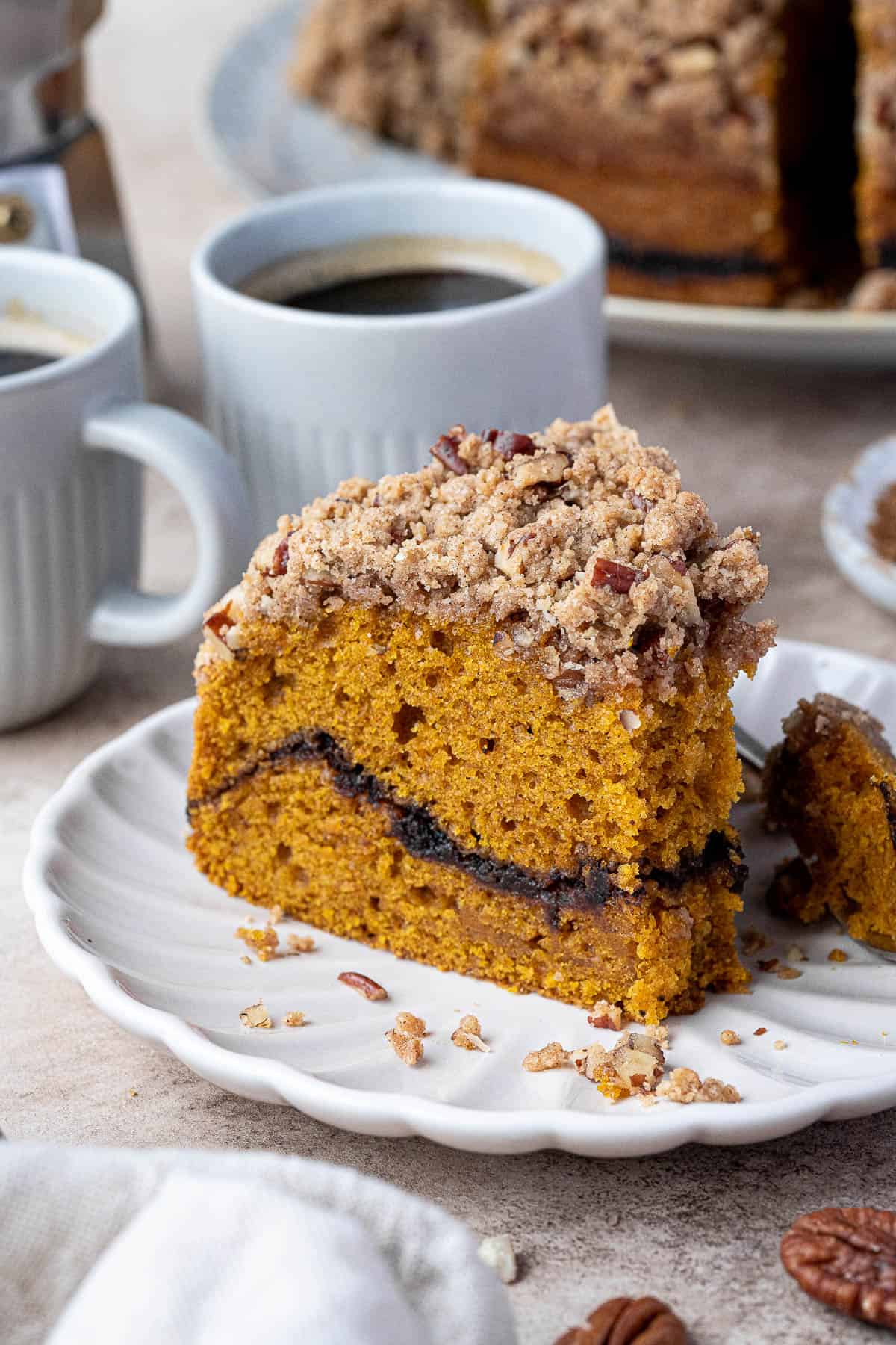 A slice of vegan pumpkin coffee cake with a forkful removed.