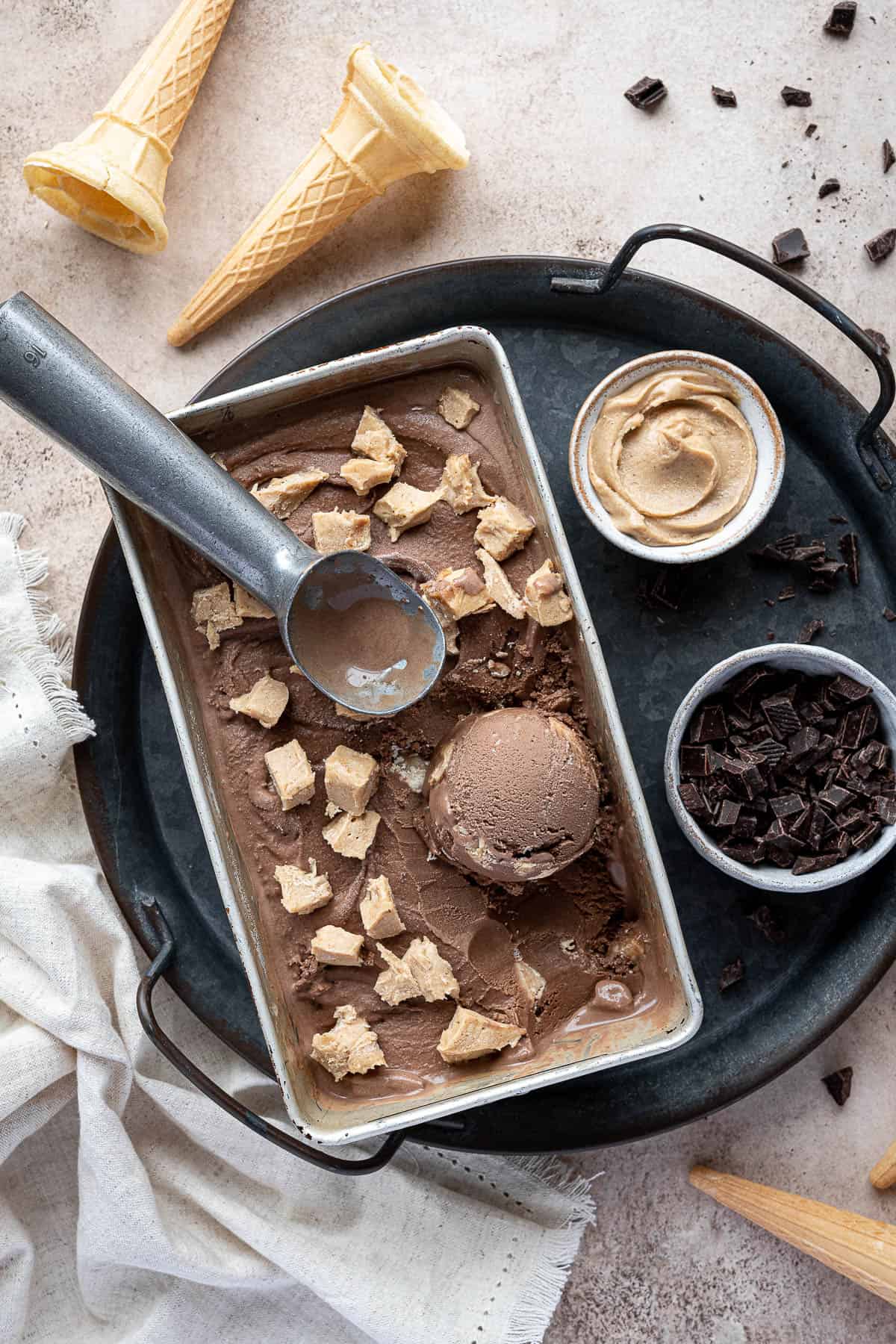 Chocolate peanut butter ice cream in a loaf tin on a metal tray.