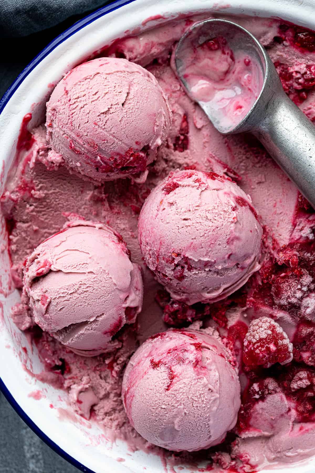 Scoops of vegan raspberry ice cream in a pie dish.