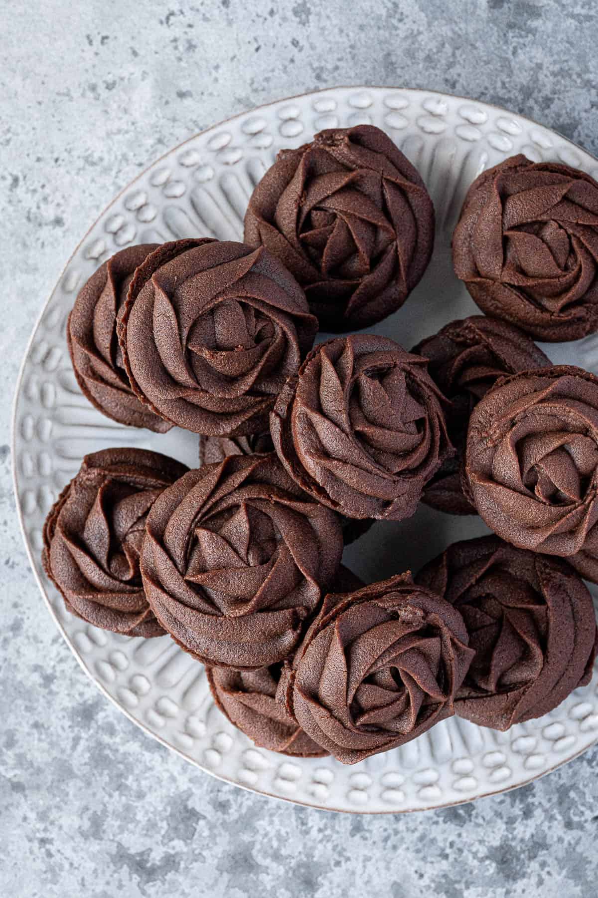 A plate of chocolate Viennese whirl biscuits.