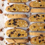 Two rows of vegan pumpkin biscotti on a sheet of baking parchment.