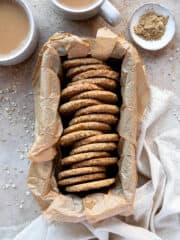 Spiced oat biscuits in a parchment lined loaf tin with cups of tea.