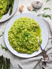 A plate of rocket pesto risotto with asparagus.