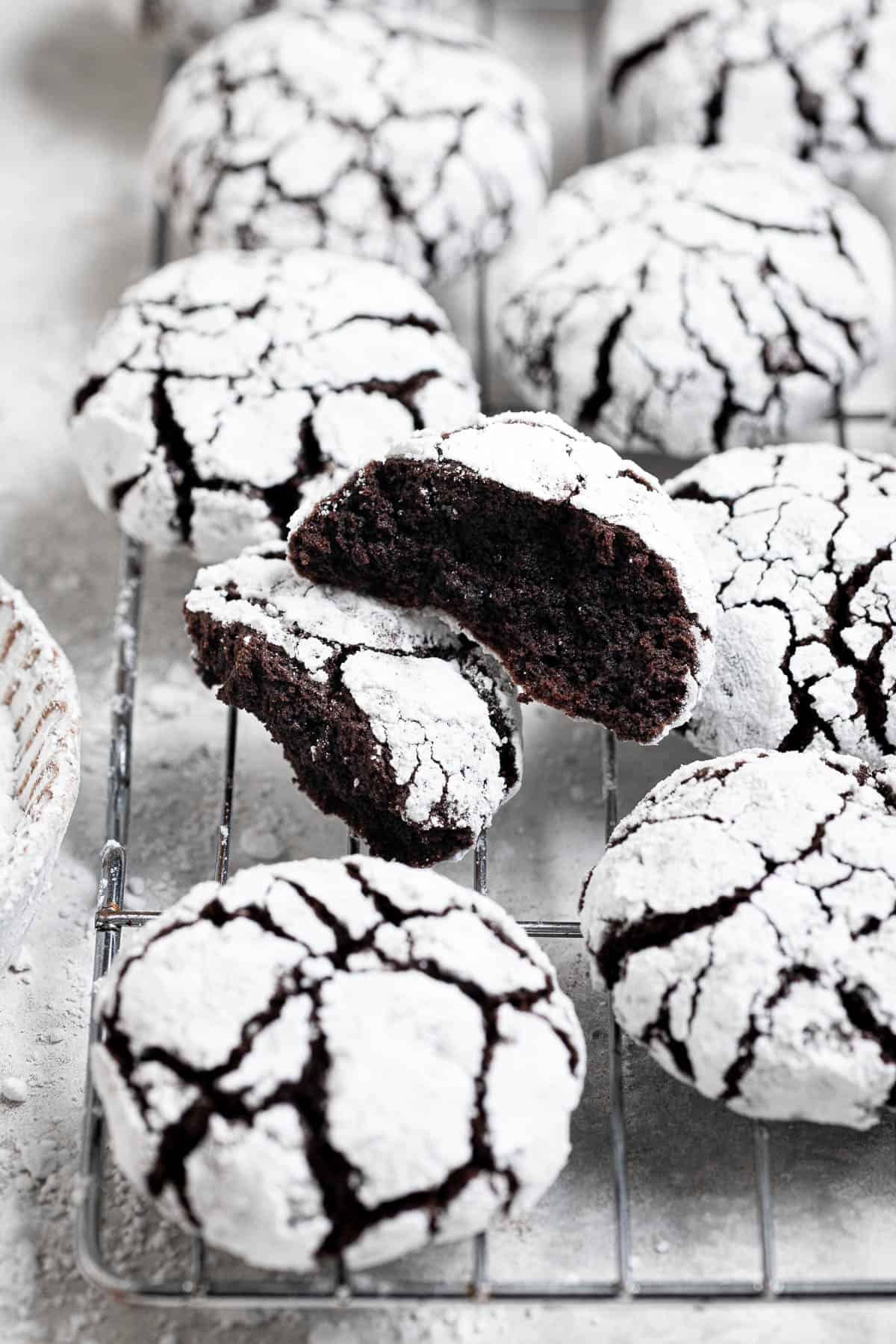 A vegan chocolate crinkle cookie broken in half.