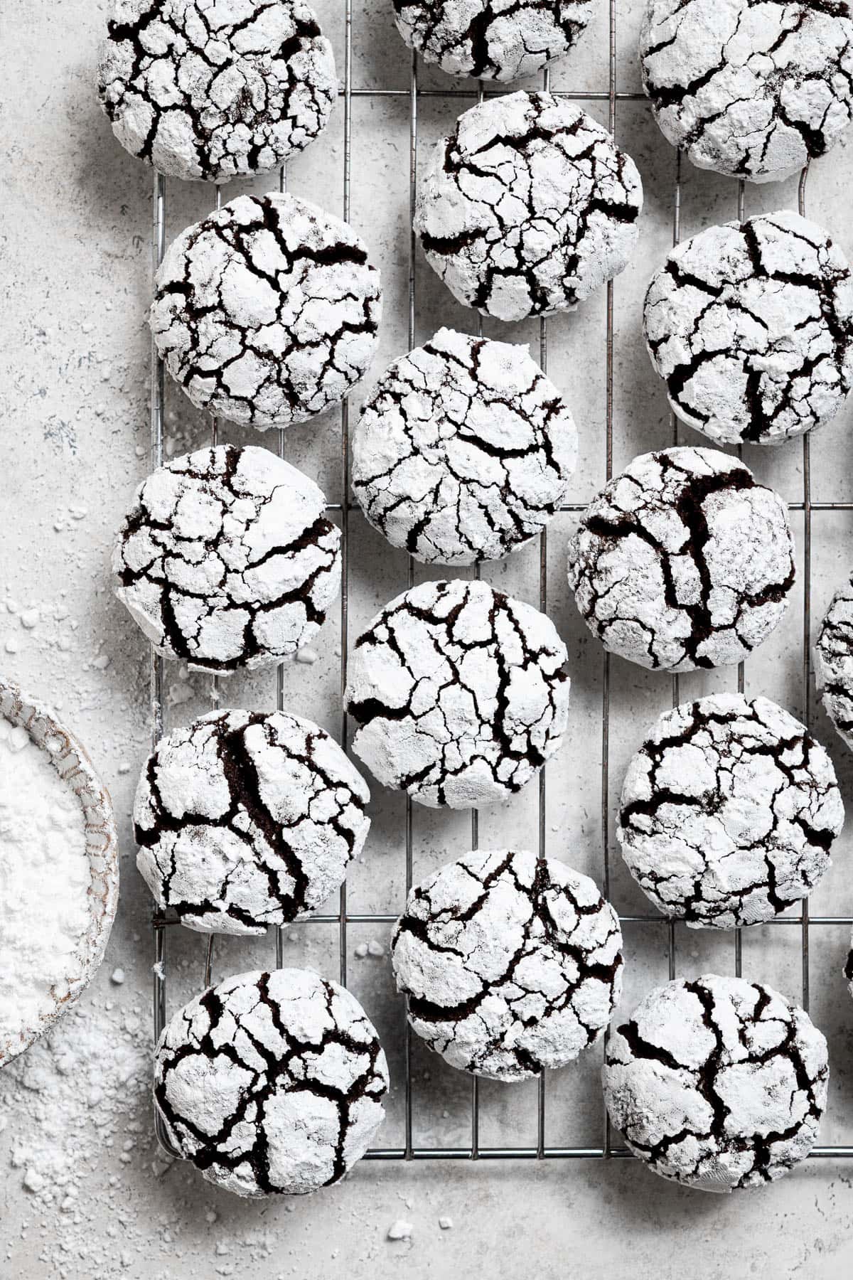 Vegan chocolate crinkle cookies on a wire cooling rack.