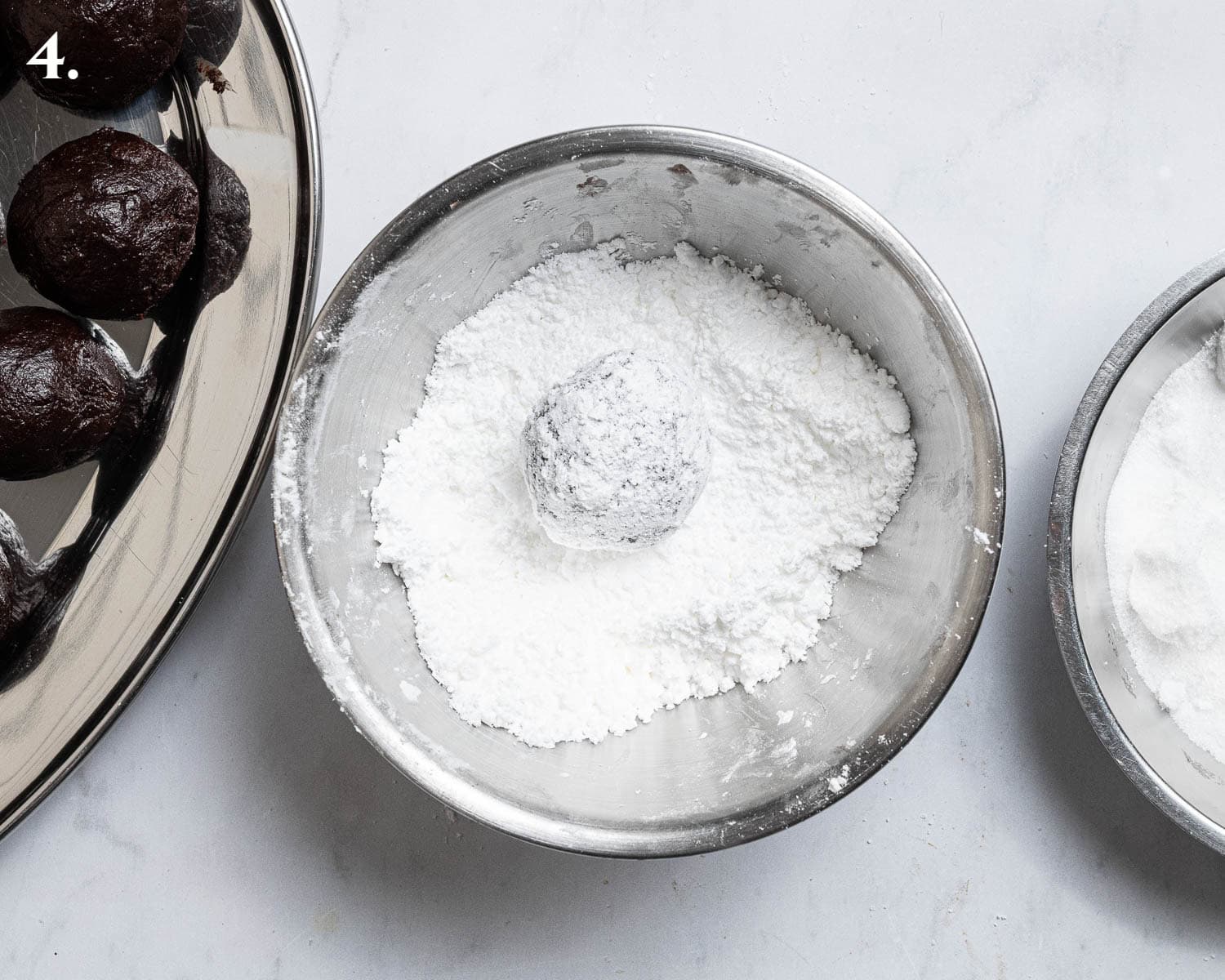 Step 4, coating the dough balls in icing sugar.