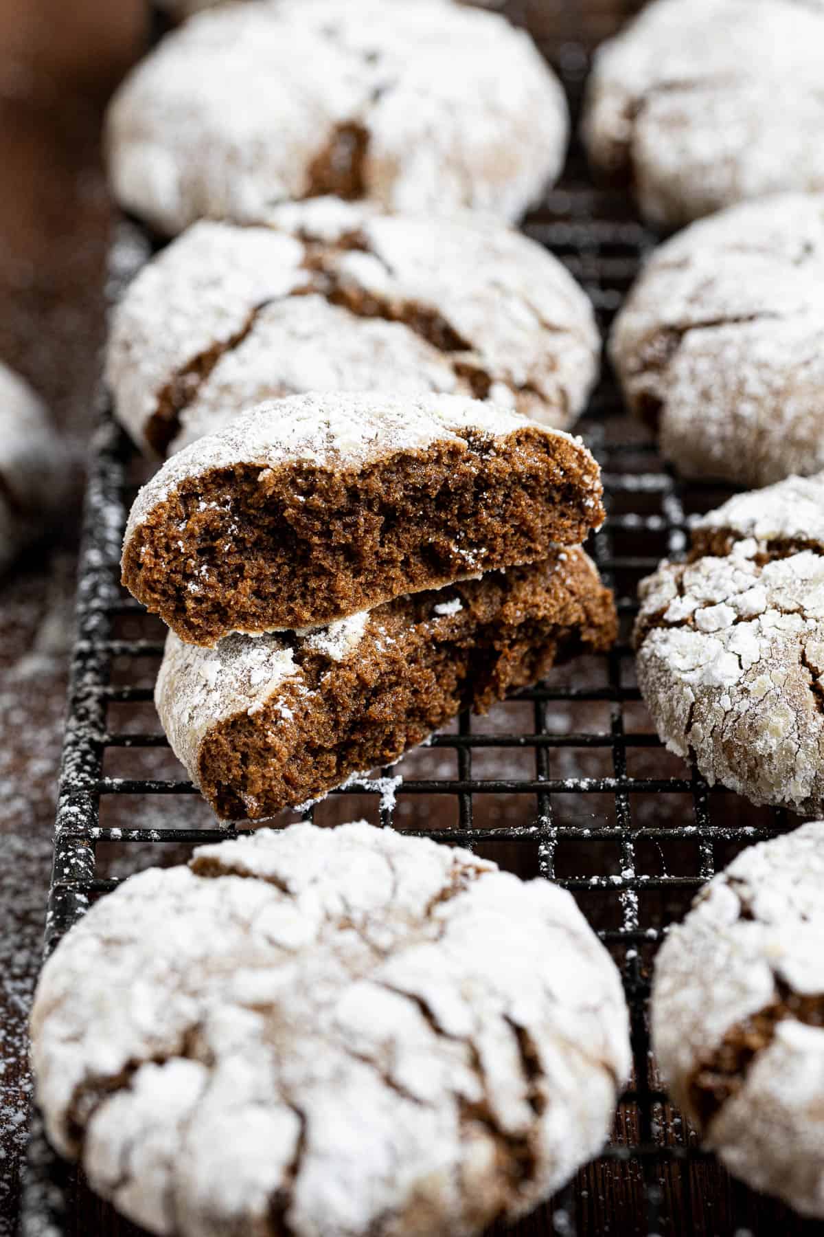 Close up of a vegan gingerbread crinkle cookie broken in half.