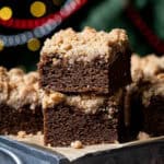 Two squares of vegan gingerbread crumb cake on top of a metal box.