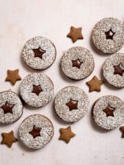 Vegan chocolate gingerbread sandwich cookies on a pink marble surface.
