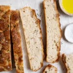 Slices of easy bubbly focaccia with bowls of olive oil and salt.