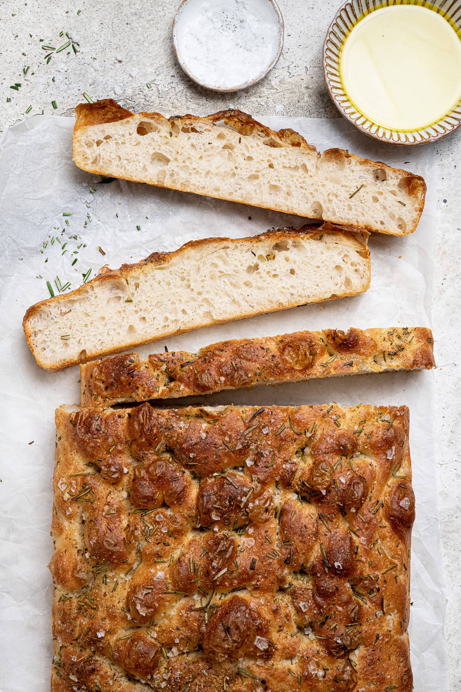 Sliced focaccia with bowls of olive oil and salt.