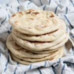 A stack of vegan yogurt flatbreads on a tea towel.