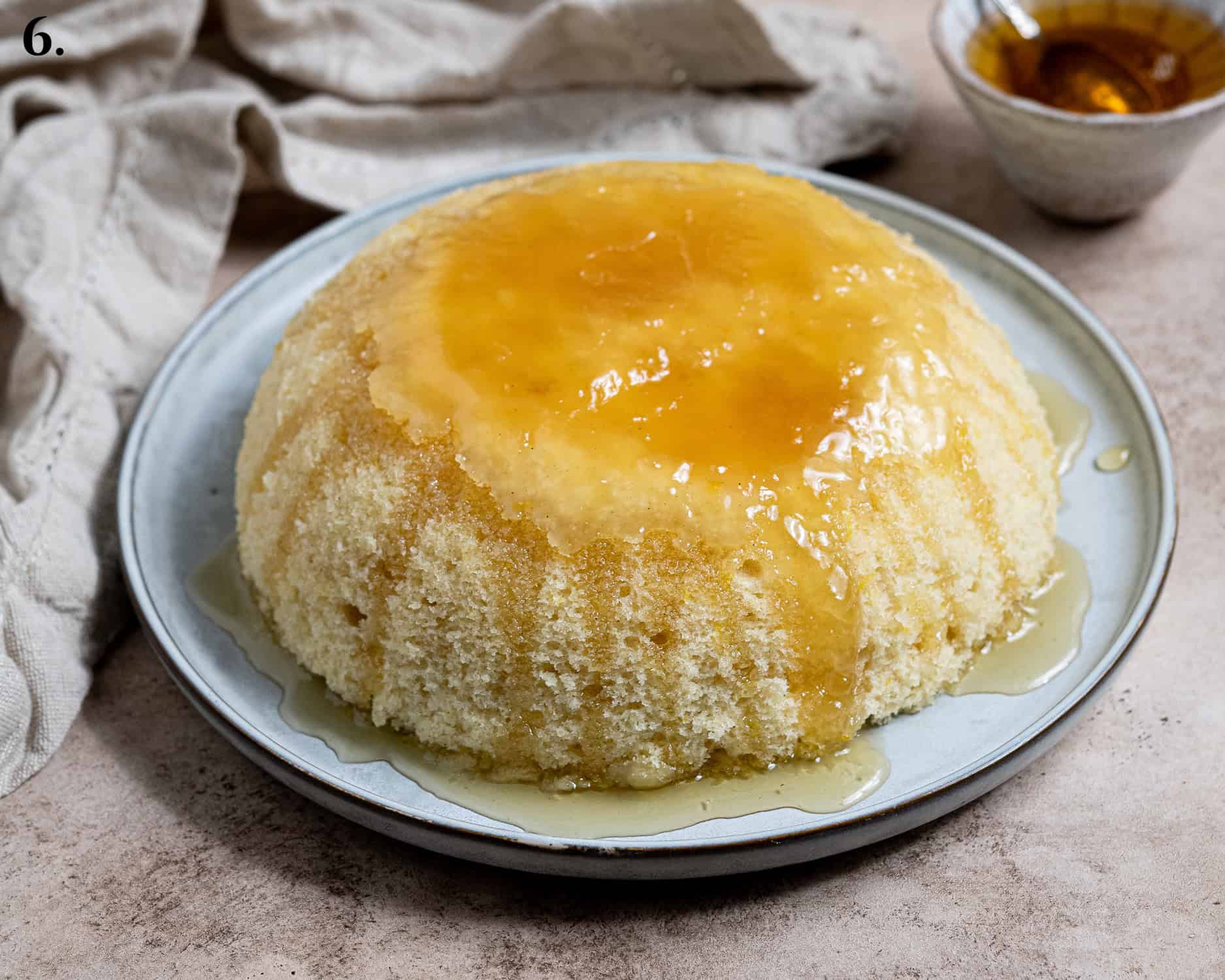 Step 6, the pudding turned out onto a plate and topped with more golden syrup.