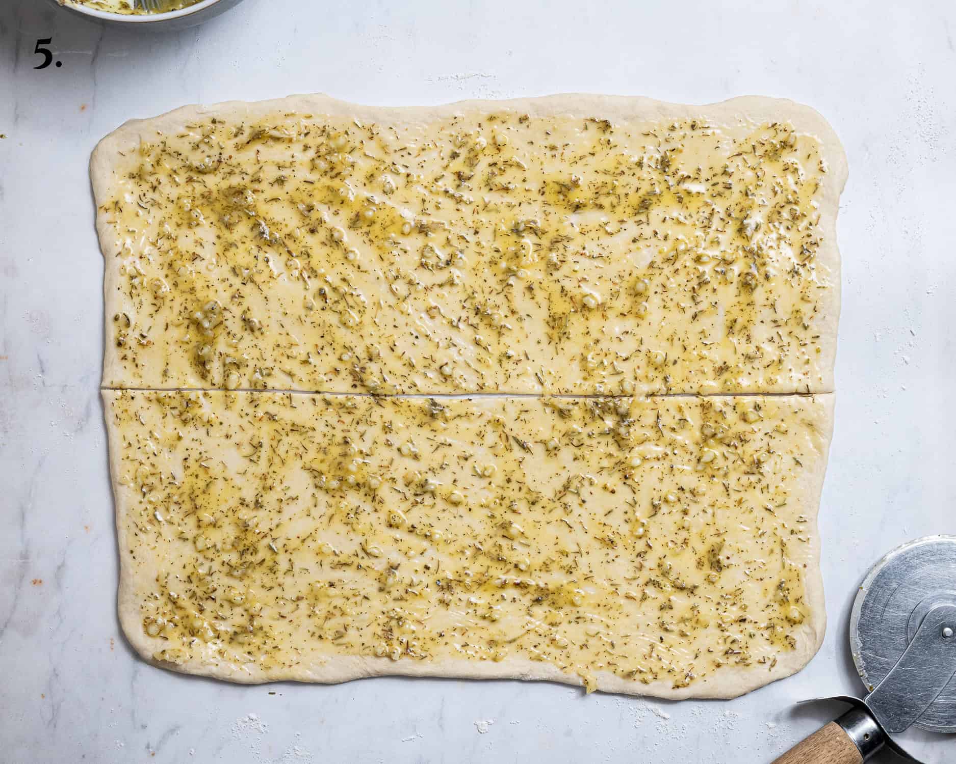 Step 5, the dough brushed with garlic butter and sliced in half.