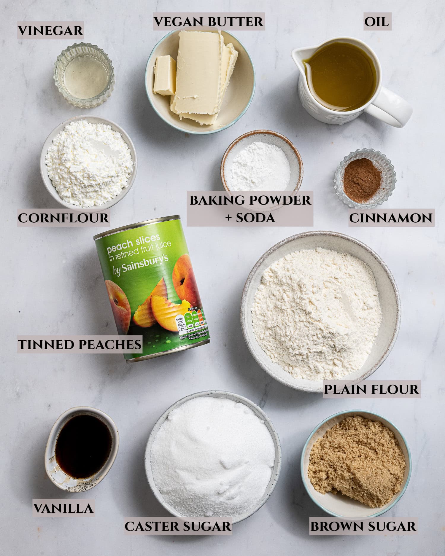 A labelled photo of the ingredients needed to make vegan peach crumble cake.
