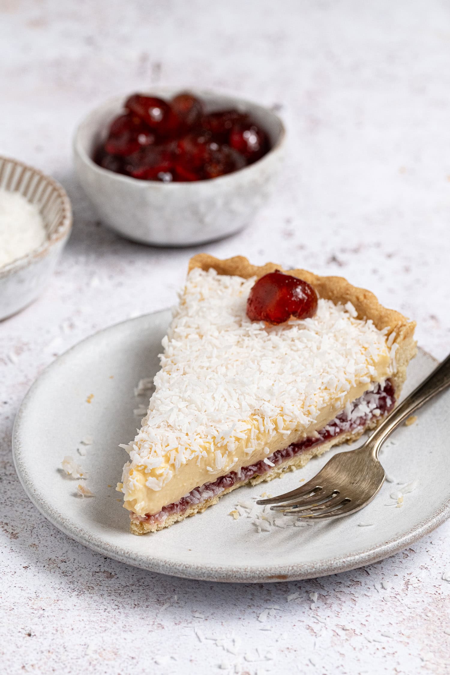A slice of vegan Manchester tart on a white plate.