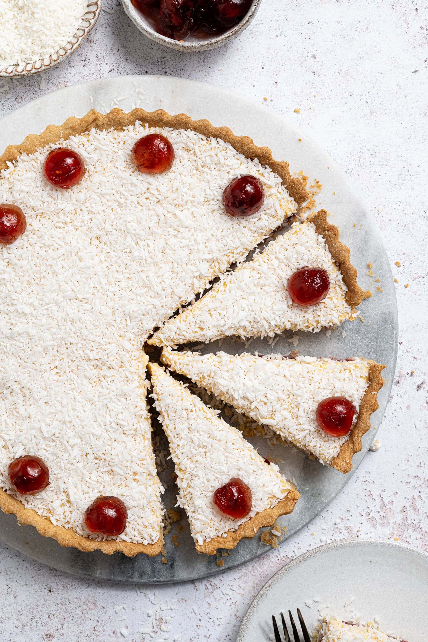 Sliced vegan Manchester tart on a marble board.