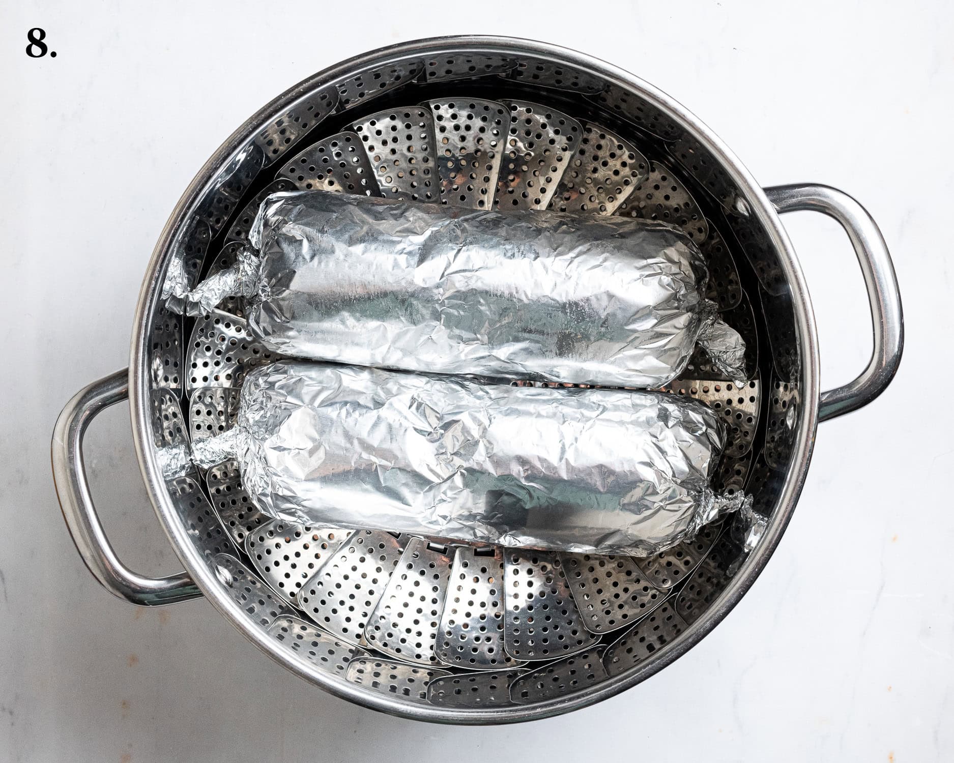 Step 8, the wrapped seitan logs in a steamer basket.
