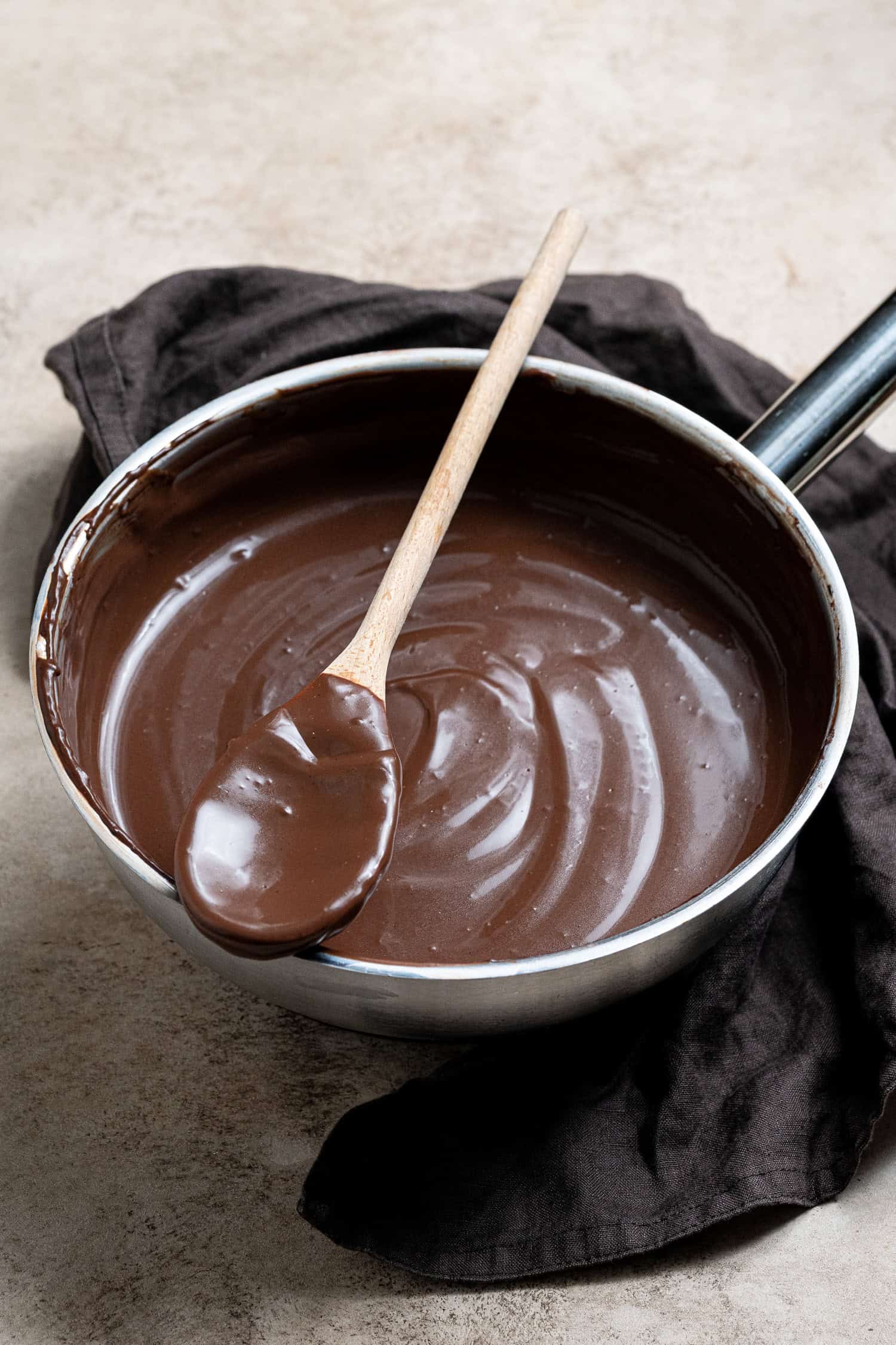A pan of vegan chocolate custard with a spoon on the side.